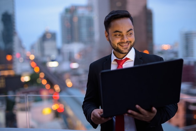 Jeune homme d'affaires indien barbu contre vue sur la ville