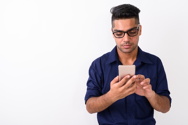 Jeune homme d'affaires indien utilisant un téléphone mobile sur blanc