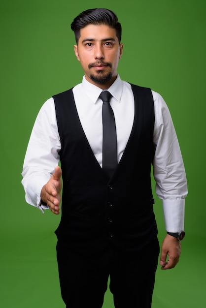 Jeune homme d'affaires iranien barbu sur vert