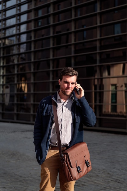 Jeune homme d'affaires marchant parler par téléphone