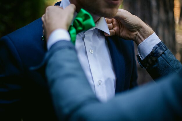 Le jeune homme d'affaires ou le marié attache le bouton de sa veste bleue. le marié attache sa veste.