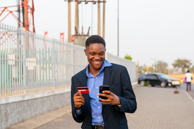 Jeune homme d'affaires noir effectuant un paiement par carte de crédit via la technologie moderne