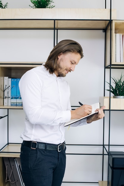 Jeune homme d&#39;affaires prenant des notes à son agenda