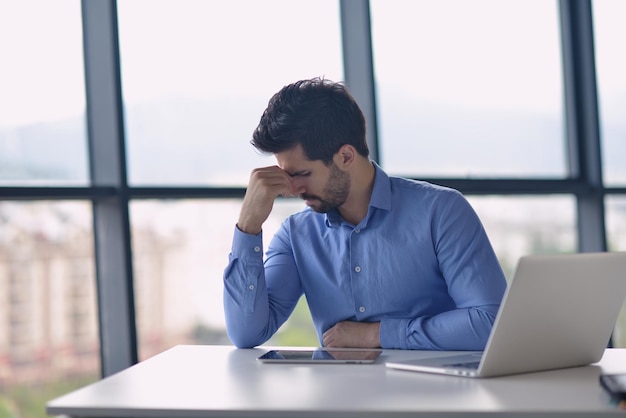 Jeune homme d'affaires avec des problèmes et du stress au bureau