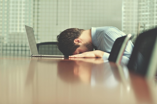 Jeune homme d'affaires avec des problèmes et du stress au bureau