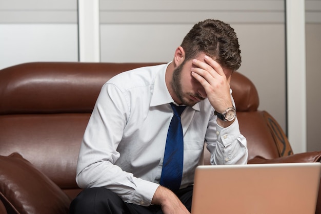 Jeune homme d'affaires avec des problèmes et du stress au bureau