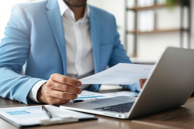 Jeune homme d'affaires professionnel latin occupé vérifiant des documents travaillant à l'ordinateur portable au bureau Businessma