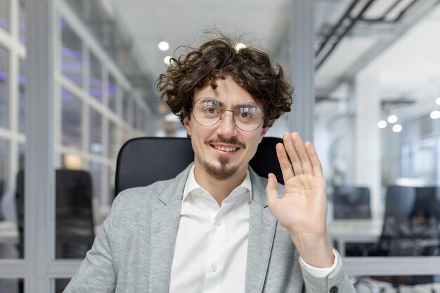 Un jeune homme d'affaires professionnel en tenue élégante salue en montrant de la positivité et de la confiance.