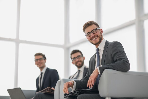 Jeune homme d'affaires prospère sur fond d'officephoto with copy space