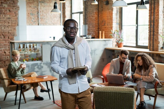 Jeune homme d'affaires prospère d'origine africaine tenant un cahier