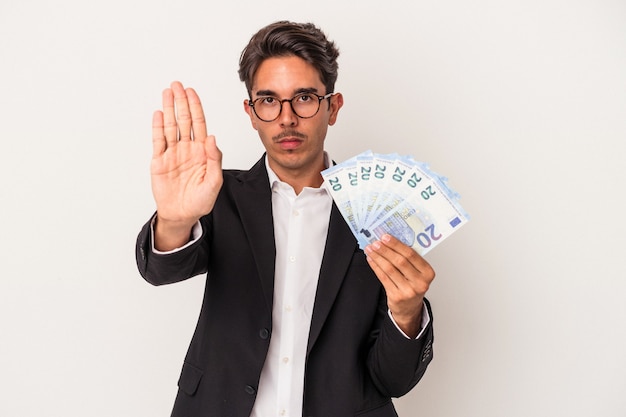 Jeune homme d'affaires de race mixte tenant des factures isolées sur fond blanc, debout avec la main tendue montrant un panneau d'arrêt, vous empêchant.