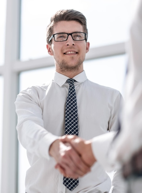 Un jeune homme d'affaires serre la main d'un concept d'entreprise partenaire