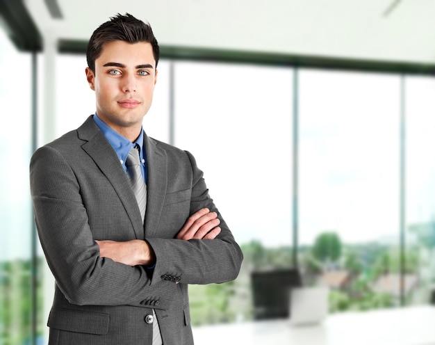 Jeune homme d&#39;affaires souriant dans son bureau