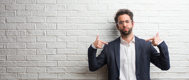 Jeune homme d&#39;affaires sympathique fier et confiant, pointer du doigt