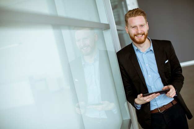 Jeune homme d&#39;affaires avec un tablet pc au bureau