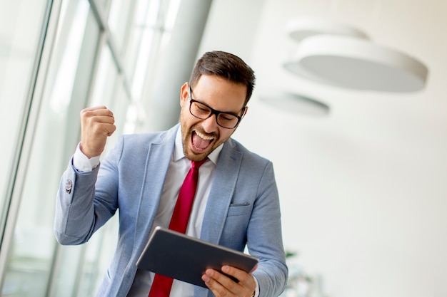 Jeune homme d&#39;affaires avec tablette numérique au bureau