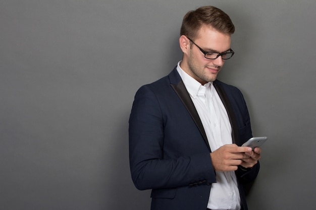 Jeune homme d'affaires avec un téléphone portable sur sa main