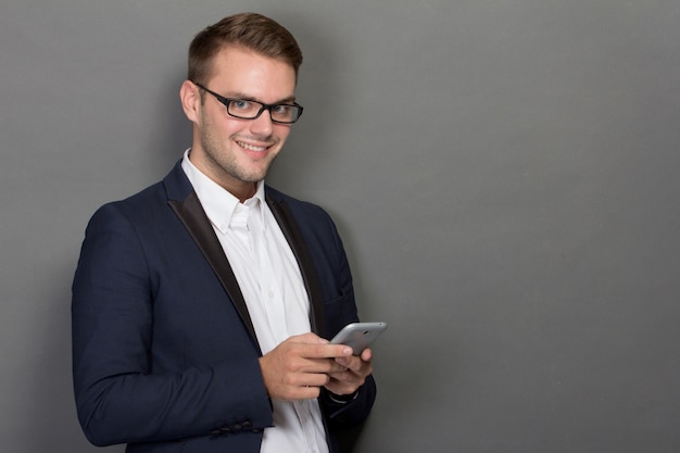 Jeune homme d'affaires avec un téléphone portable sur sa main