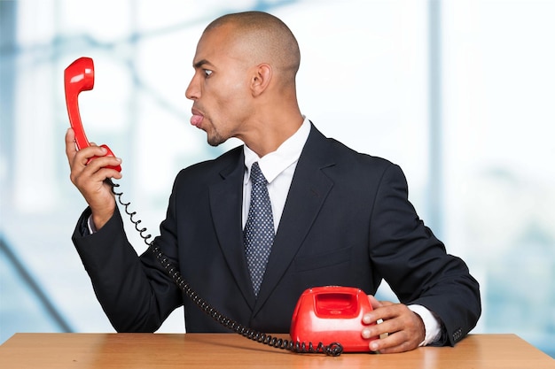 Photo jeune homme d'affaires avec téléphone vintage rouge