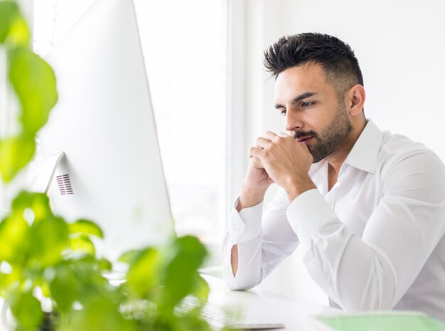 Jeune homme d&#39;affaires travaillant au bureau sur le bureau d&#39;ordinateur