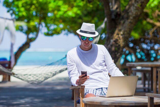 Jeune homme d'affaires travaillant dans un café en plein air