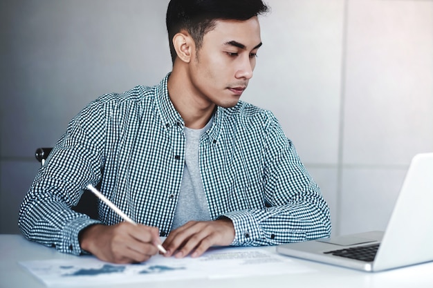 Jeune homme d&#39;affaires travaillant sur ordinateur portable au bureau.