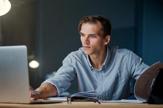 Le jeune homme d'affaires travaille avec des documents la nuit