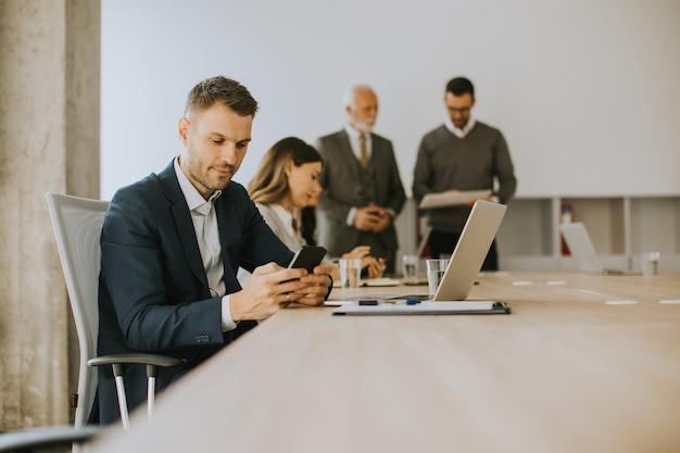 Jeune homme d'affaires utilisant un téléphone portable au bureau