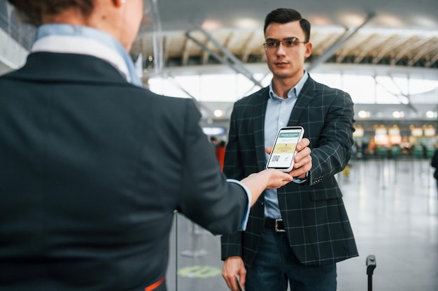 Un jeune homme d'affaires en vêtements formels est à l'aéroport pendant la journée