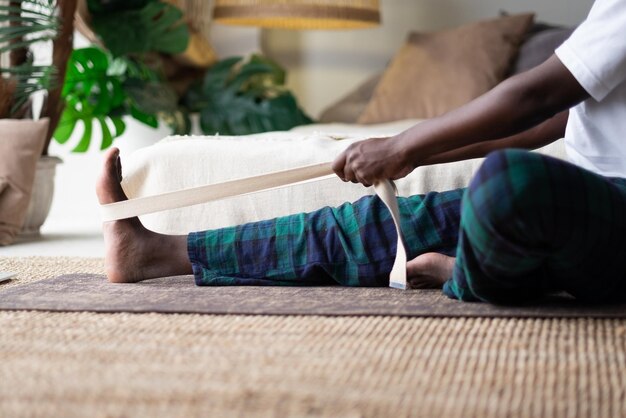 Jeune homme africain assis en janushirshasana assis en position de flexion vers l'avant à la maison