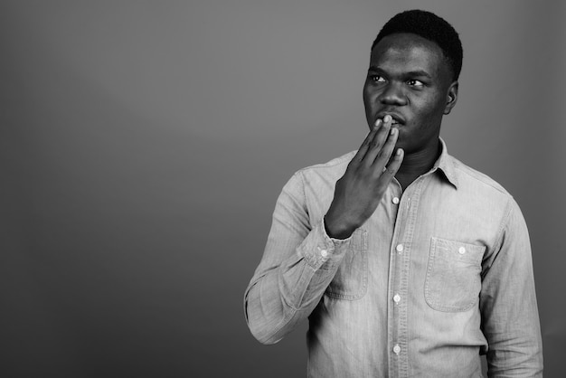 jeune homme africain portant une chemise en jean. Photo noir et blanc