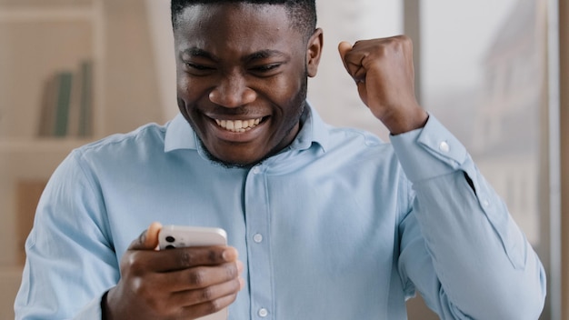 Un jeune homme africain surpris de recevoir un bon message sur son téléphone portable gagne un pari en ligne réjouis-toi en passant mobile