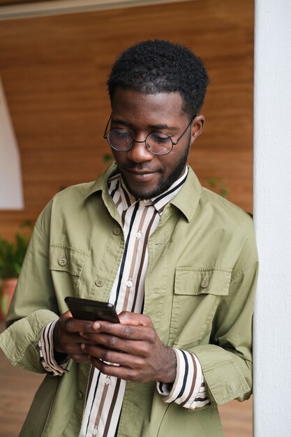 Jeune homme africain travaillant en ligne sur un téléphone portable