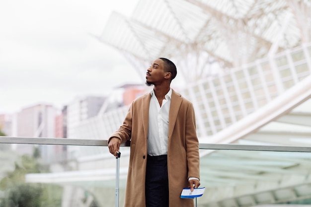 Jeune homme afro-américain attendant son vol dans un aéroport moderne