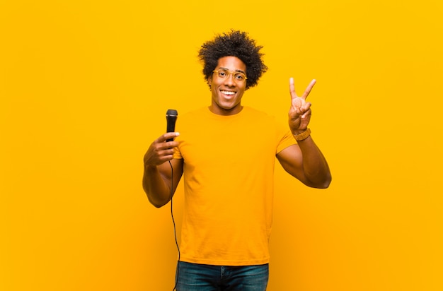 Jeune homme afro-américain avec un chant de microphone