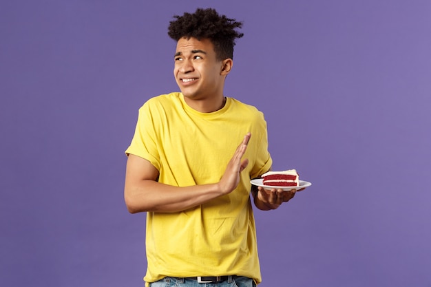 Jeune homme afro-américain en chemise jaune montrant le geste.