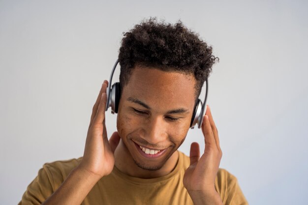 Jeune homme afro-américain, écouter de la musique funky à l'aide d'un casque sans fil.