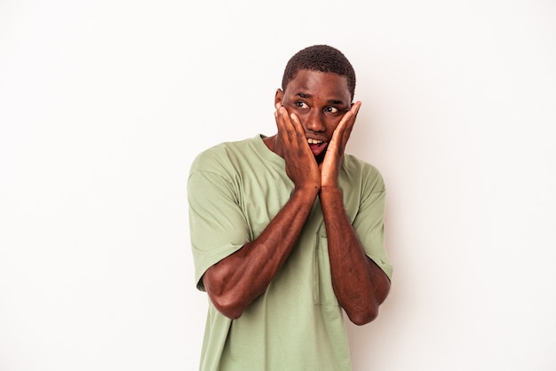 Jeune homme afro-américain isolé sur fond blanc effrayé et effrayé.