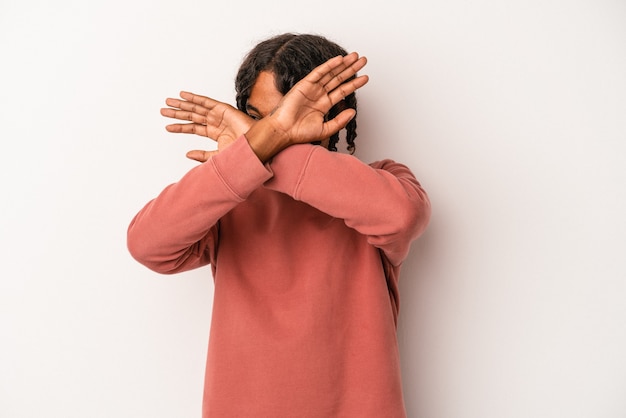 Jeune homme afro-américain isolé sur fond blanc en gardant les deux bras croisés, concept de déni.