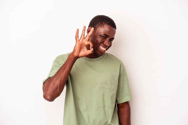 Jeune homme afro-américain isolé sur fond blanc joyeux et confiant montrant un geste ok