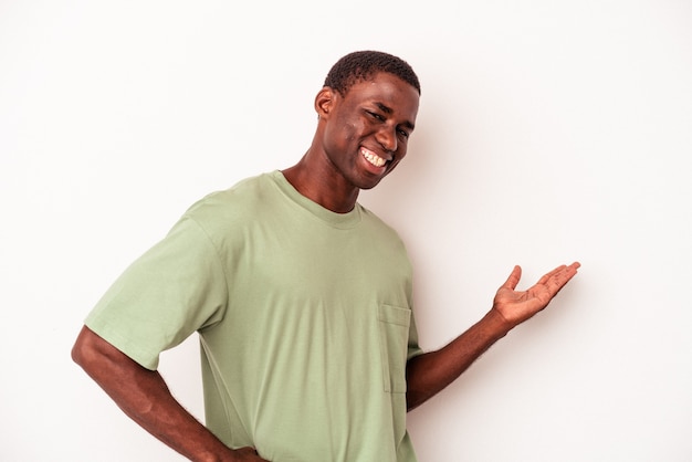 Jeune homme afro-américain isolé sur fond blanc montrant une expression de bienvenue.