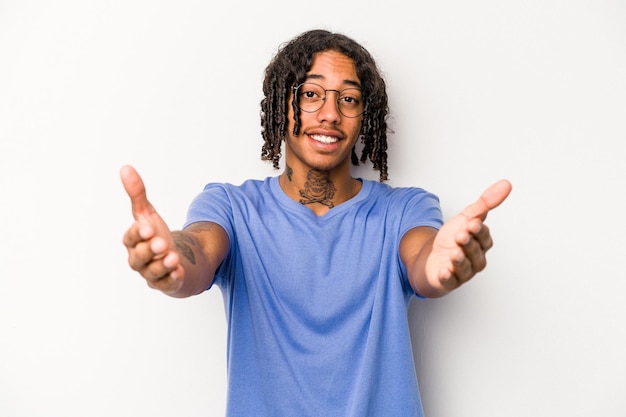 Jeune homme afro-américain isolé sur fond blanc montrant une expression de bienvenue