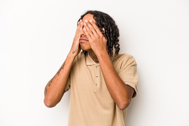 Jeune homme afro-américain isolé sur fond blanc peur couvrant les yeux avec les mains