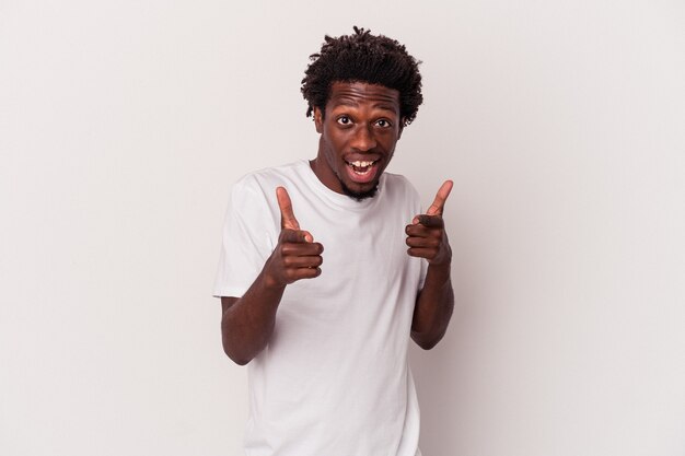 Jeune homme afro-américain isolé sur fond blanc pointant vers l'avant avec les doigts.