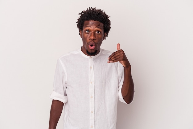 Jeune homme afro-américain isolé sur fond blanc en riant de quelque chose, couvrant la bouche avec les mains.