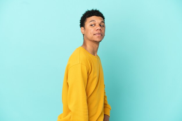 Jeune homme afro-américain isolé sur fond bleu. Portrait