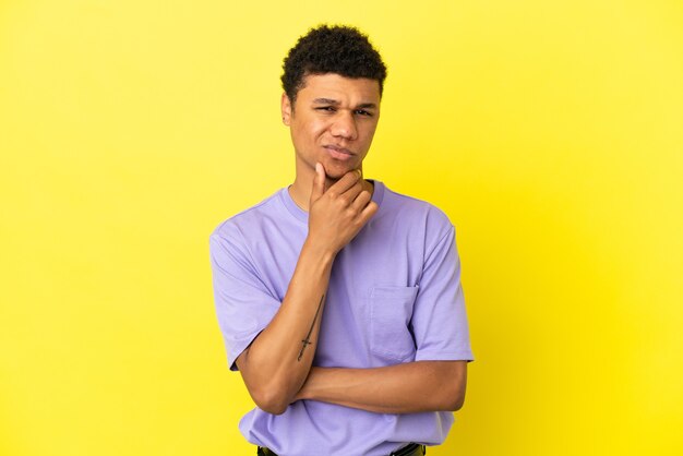 Jeune Homme Afro-américain Isolé Sur Fond Jaune Pensant