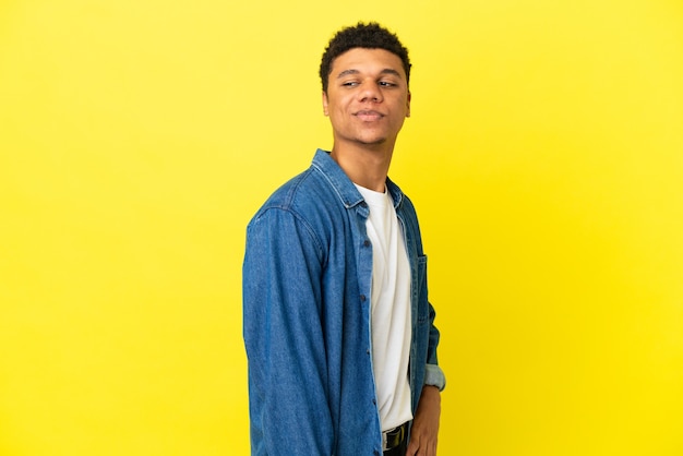 Jeune homme afro-américain isolé sur fond jaune. Portrait