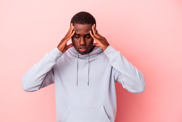 Jeune Homme Afro-américain Isolé Sur Fond Rose Touchant Les Temples Et Ayant Des Maux De Tête.