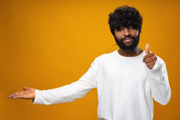 Jeune homme afro-américain montrant joyeusement l'espace de copie